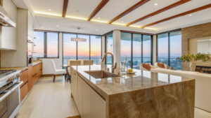 A newly remodeled kitchen with a beautiful waterfall edge countertop. A high quality interior designer understands not just color palettes but also textures and aesthetics.