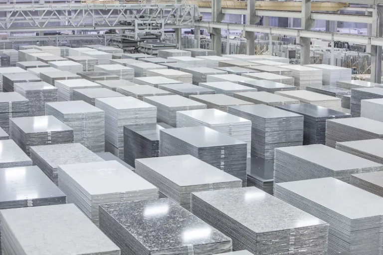Quartz countertop slabs at a modern fabrication facility, showing stacks of polished engineered stone ready for cutting and finishing.