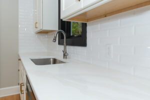 Modern kitchen with white quartz countertops.