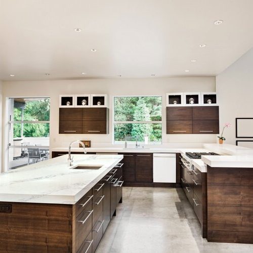 White quartz kitchen with natural wood cabinets.